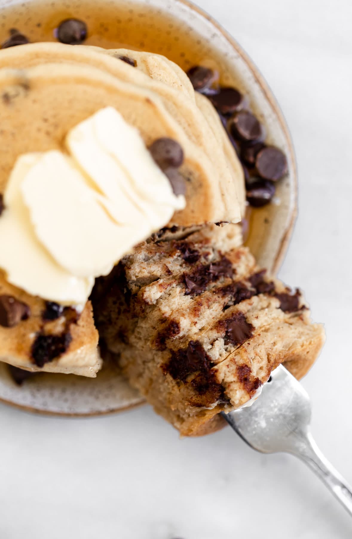 Gluten free chocolate chip pancakes with a bite taken out to show the texture.