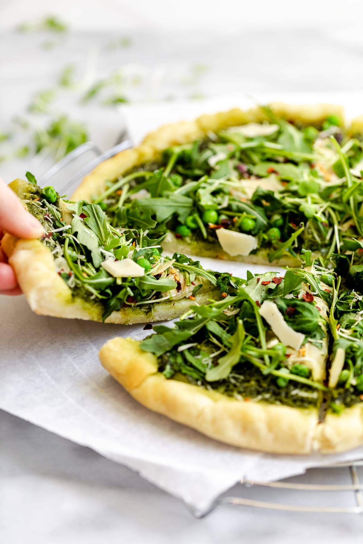 gluten free pizza topped with pesto and arugula