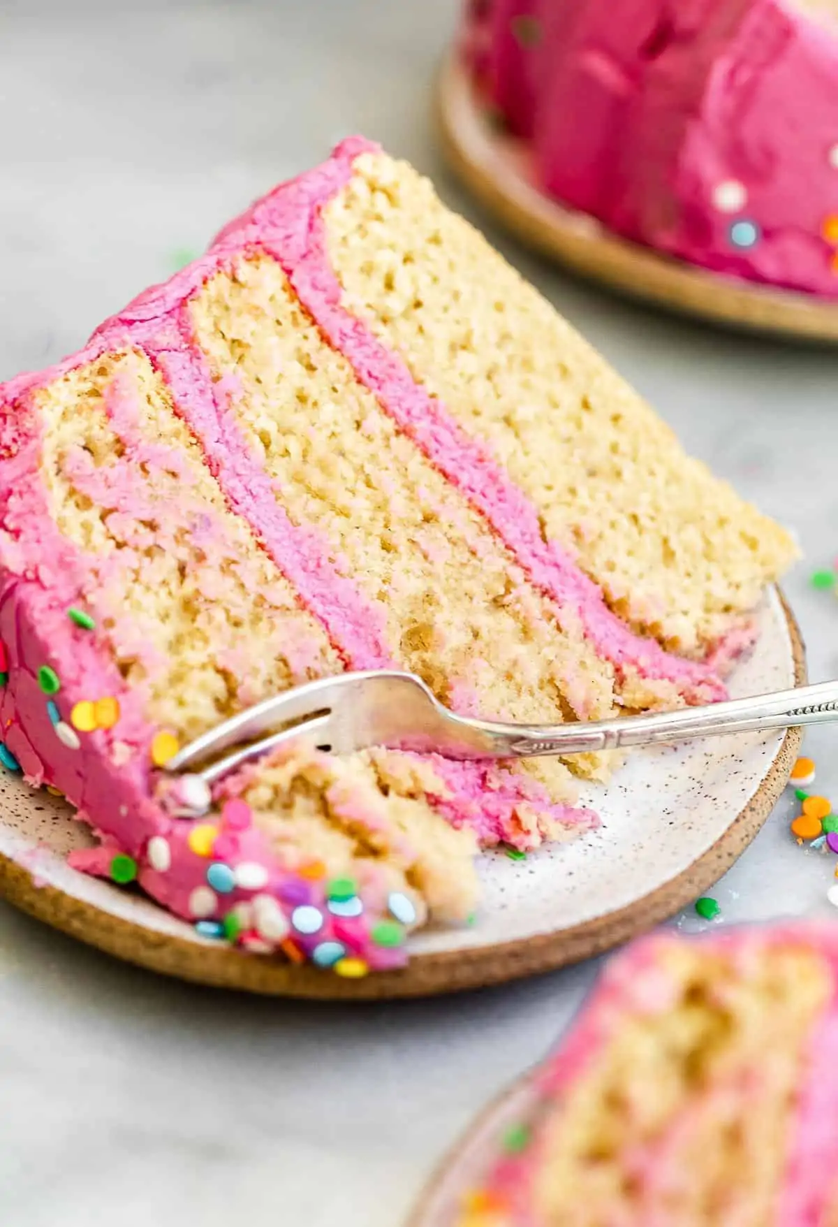 vanilla cake with pink frosting on a plate
