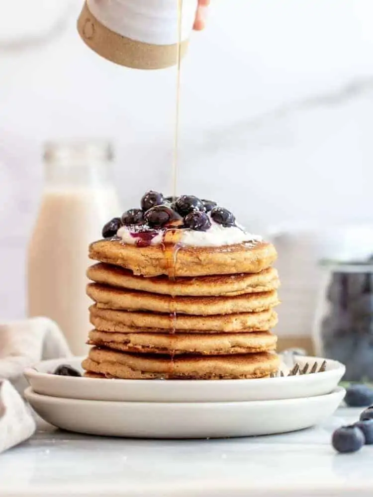 Almond flour pancakes stacked on two plates.