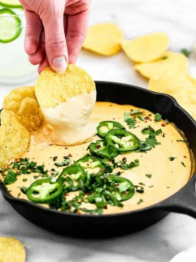 chip dipping into the queso