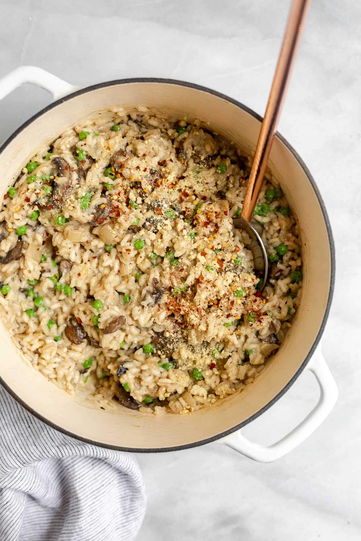 Large pot with vegan mushroom risotto with a spoon on the side.