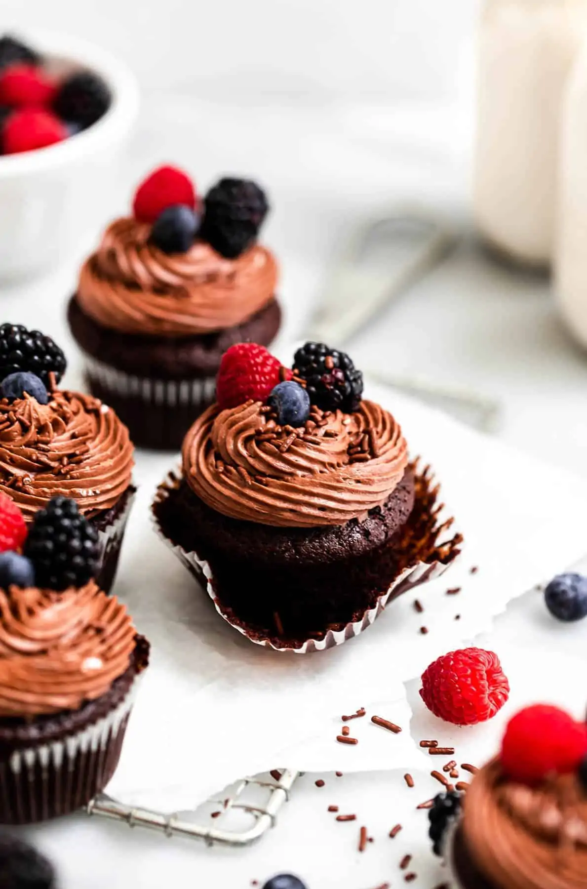 almond flour chocolate cupcakes with frosting and berries on top