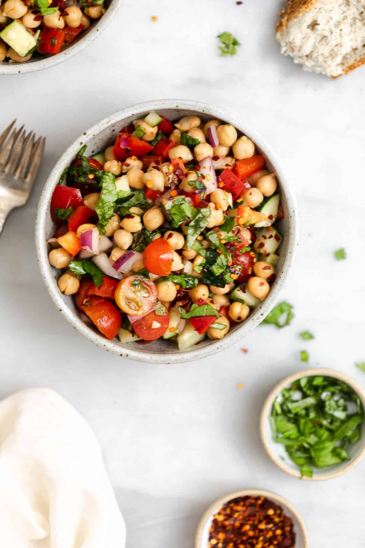 two small bowls with the final chickpea salad with basil on top