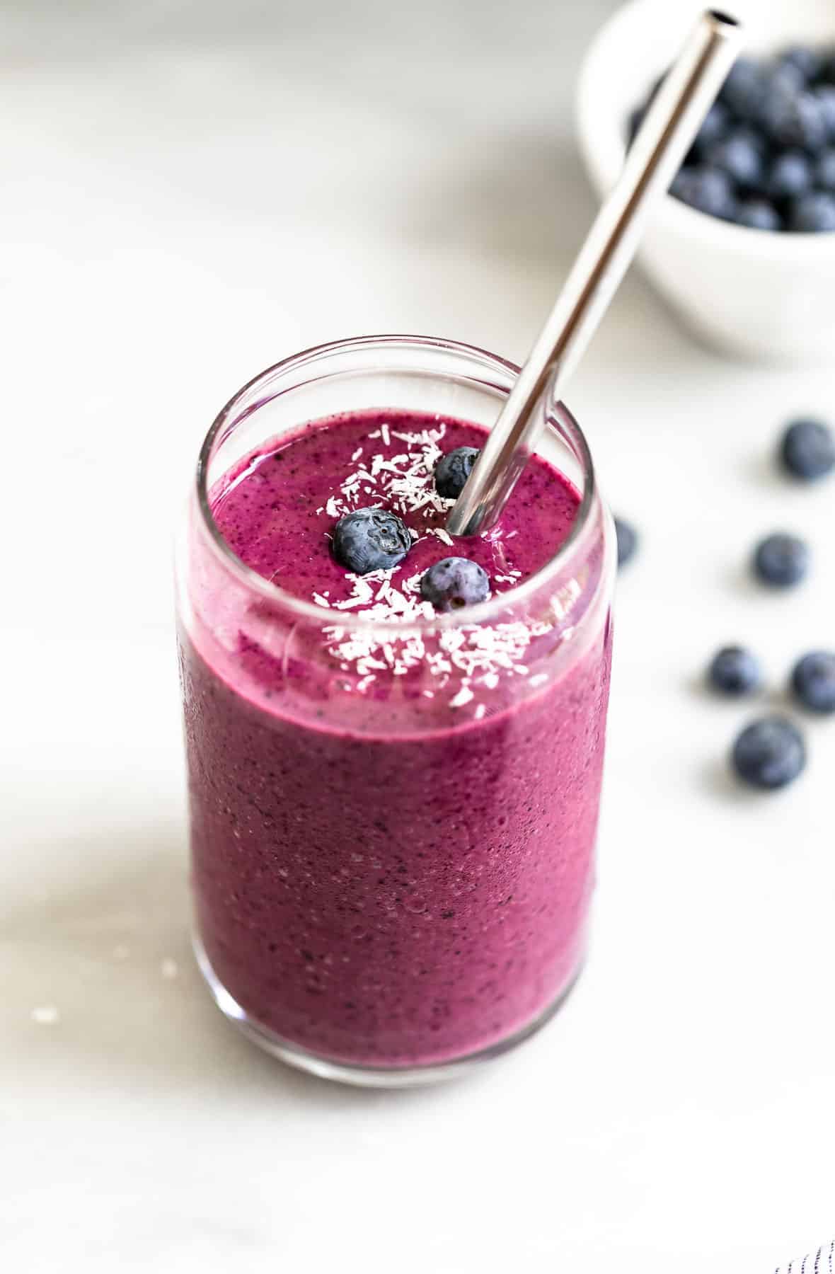 one glass with the smoothie and blueberries