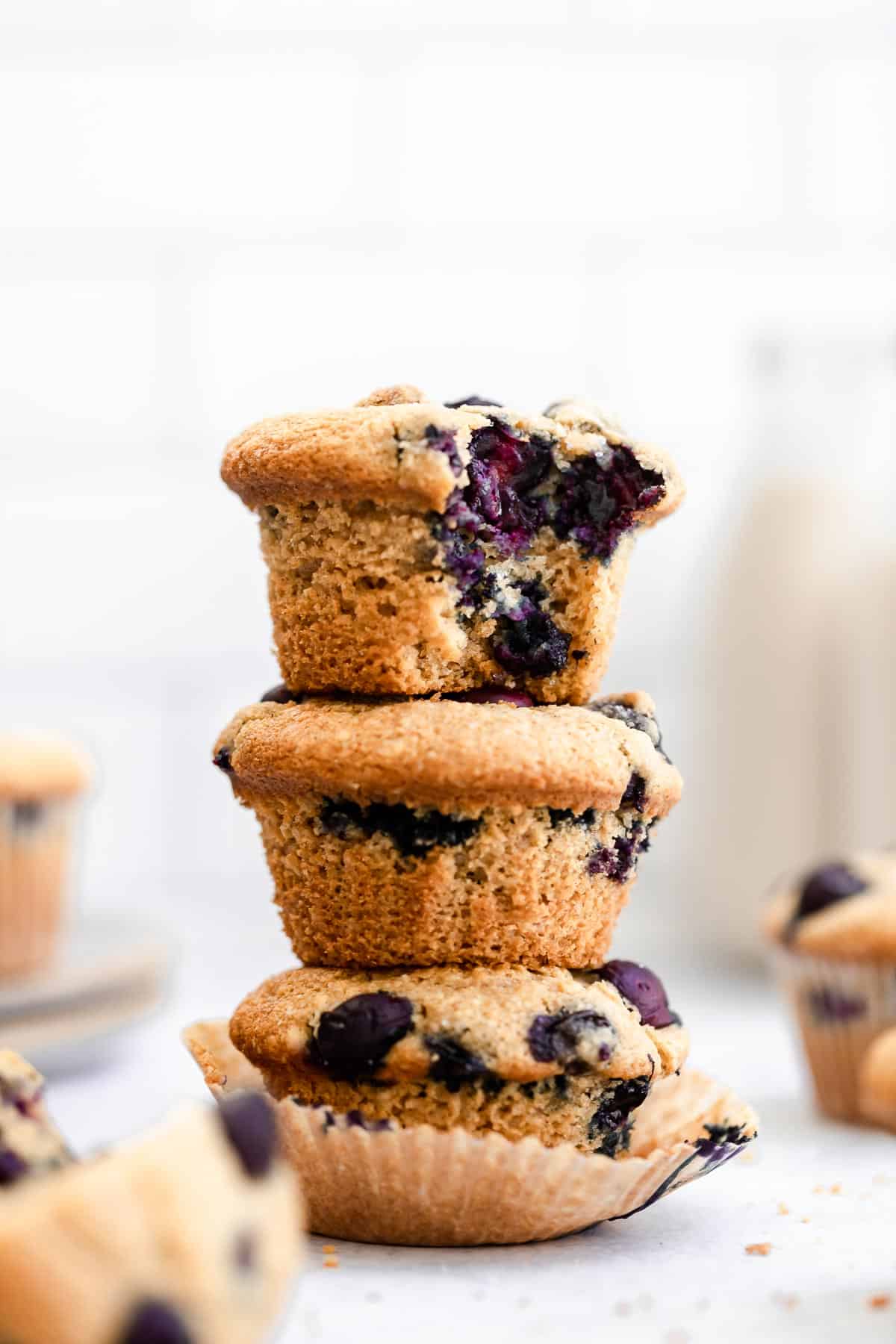 three blueberry muffins with a bite taken out