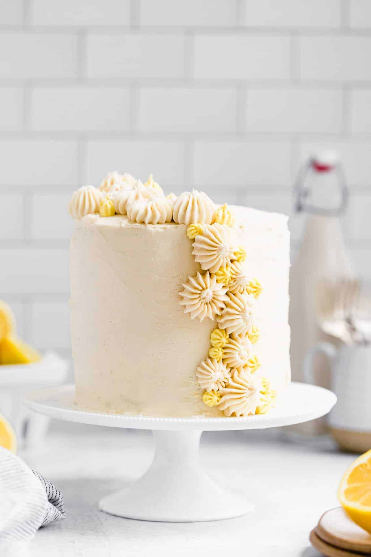 gluten free lemon cake on a cake stand with lemon frosting