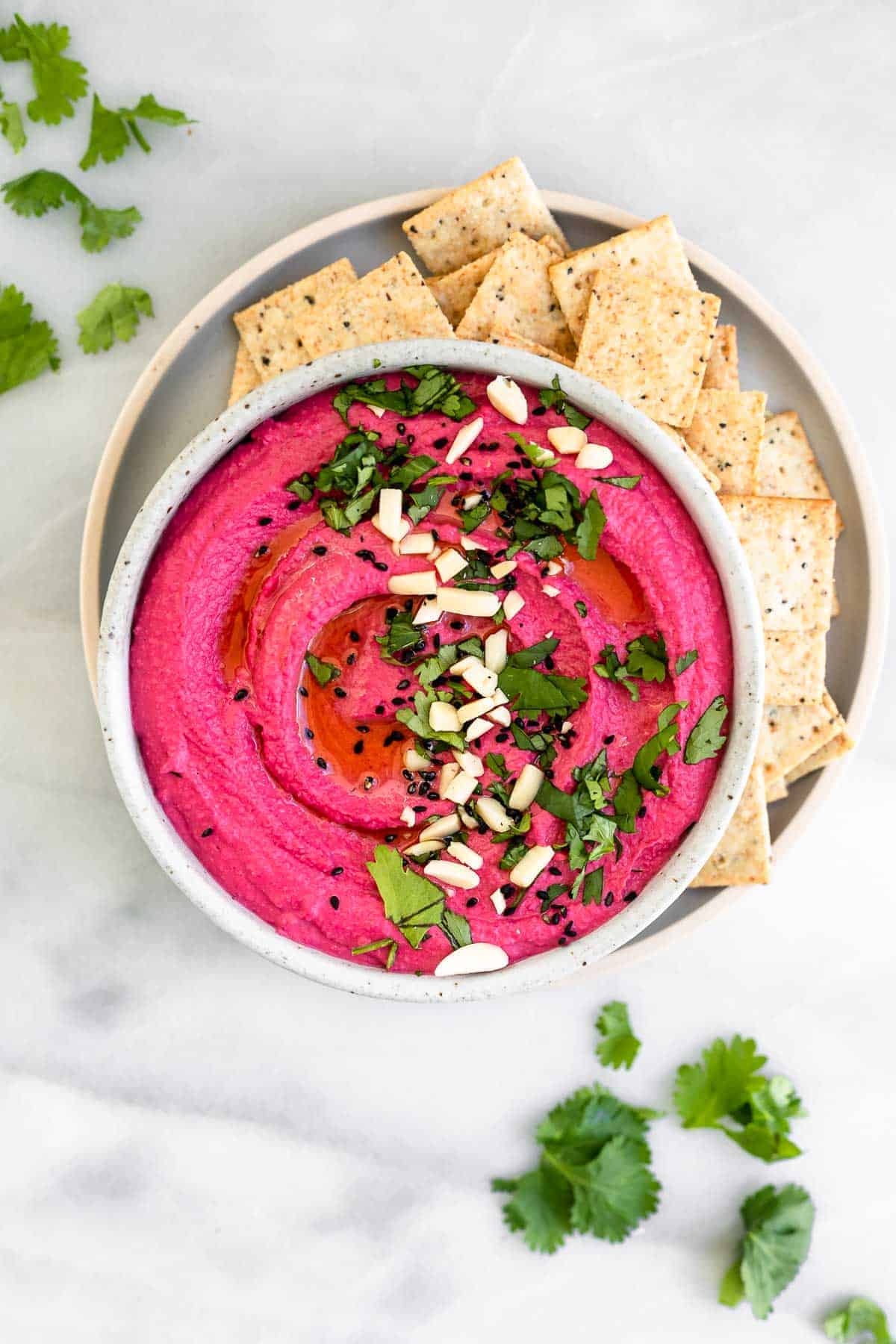 roasted beet hummus in a bowl with crackers