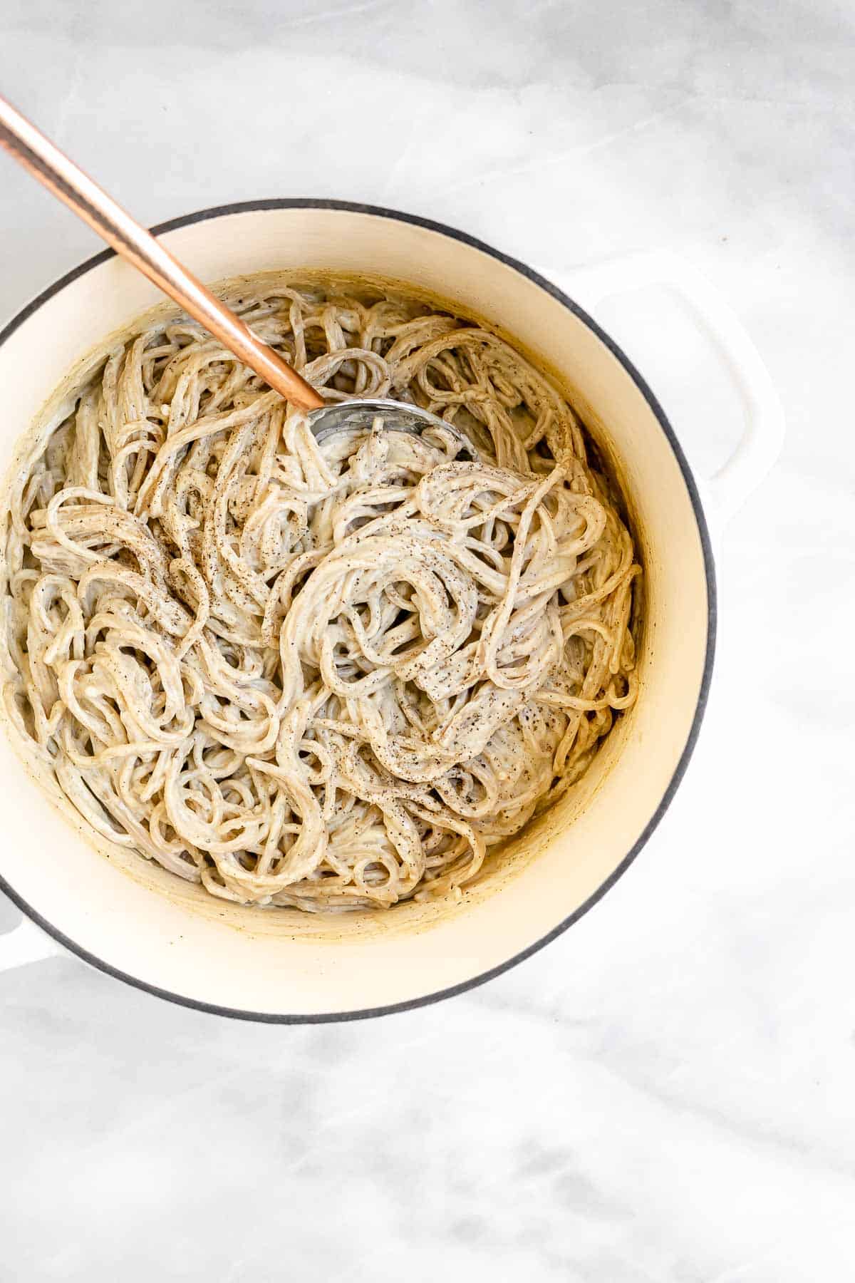 large white pot with spaghetti and cashew cheese sauce