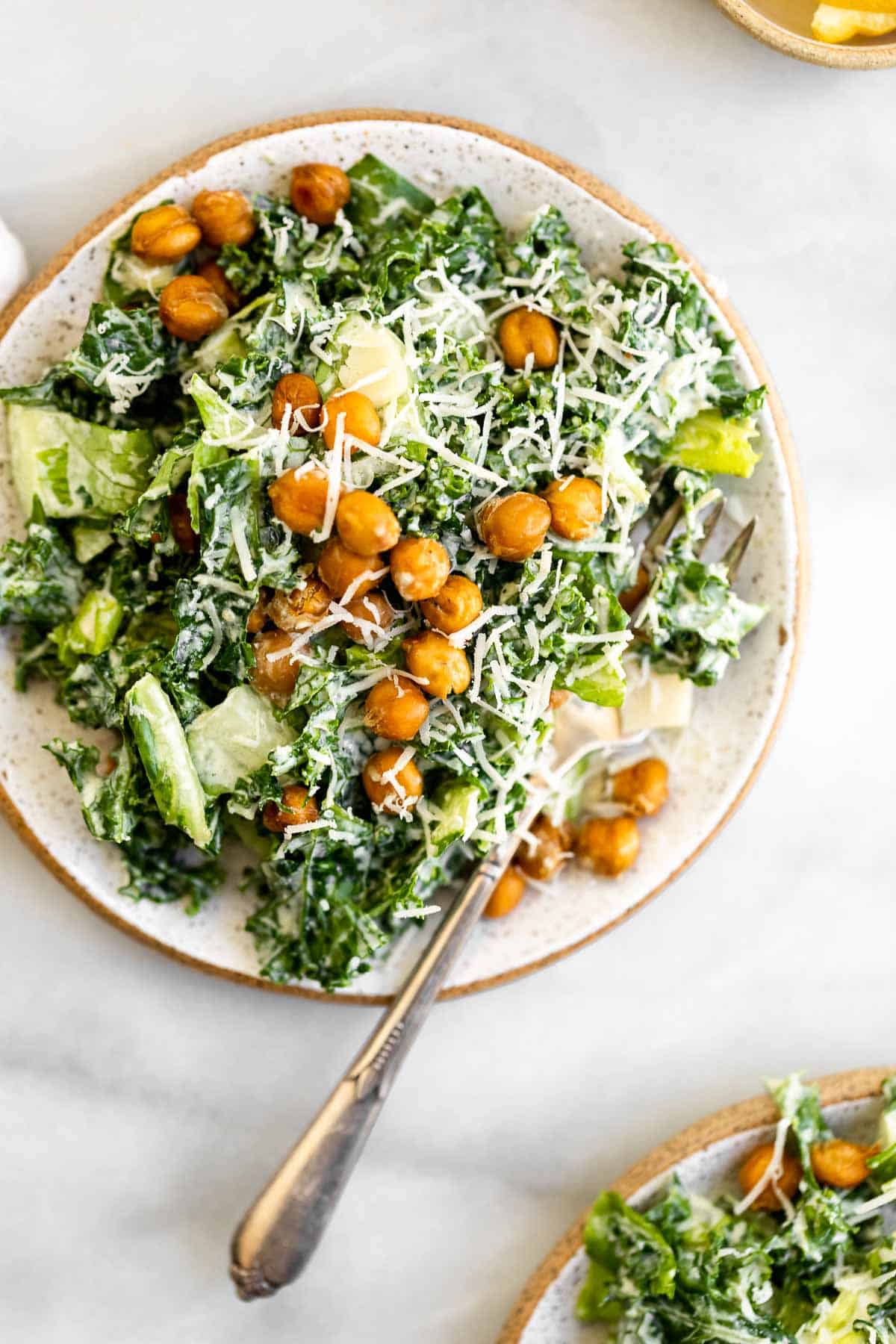 vegan kale caesar salad on a plate with a fork