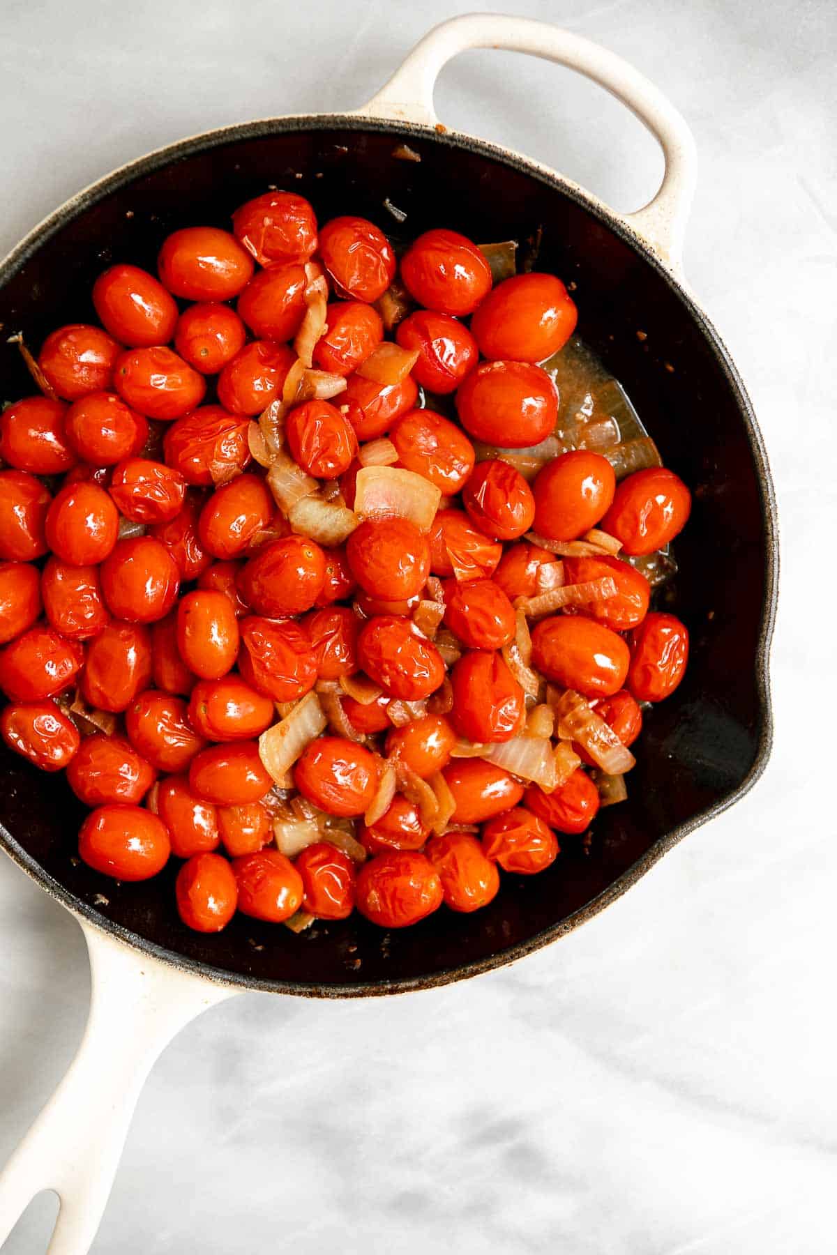 tomatoes and onions sauteeing in a pot