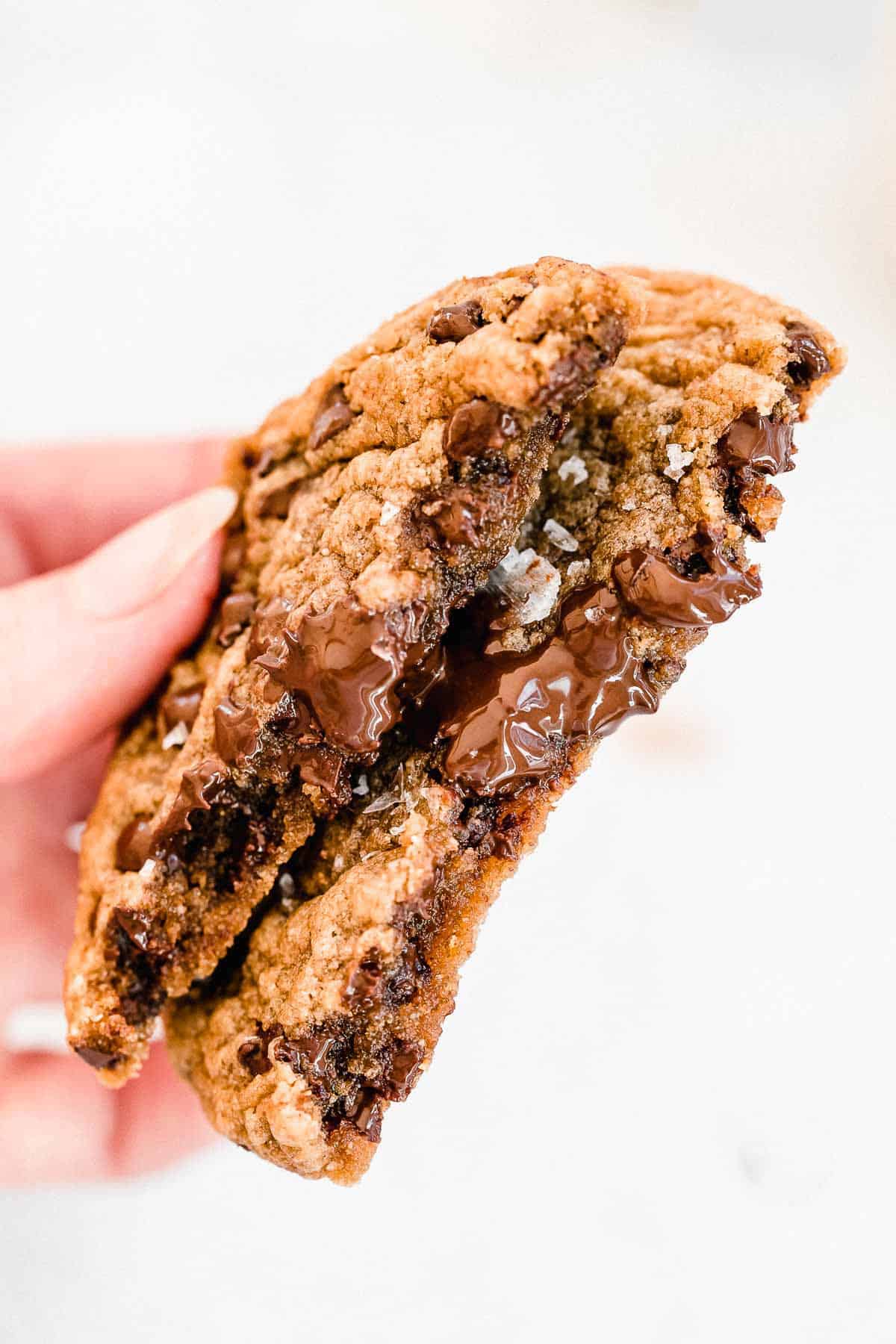 peanut butter cookie ripped in half with melted chocolate chips