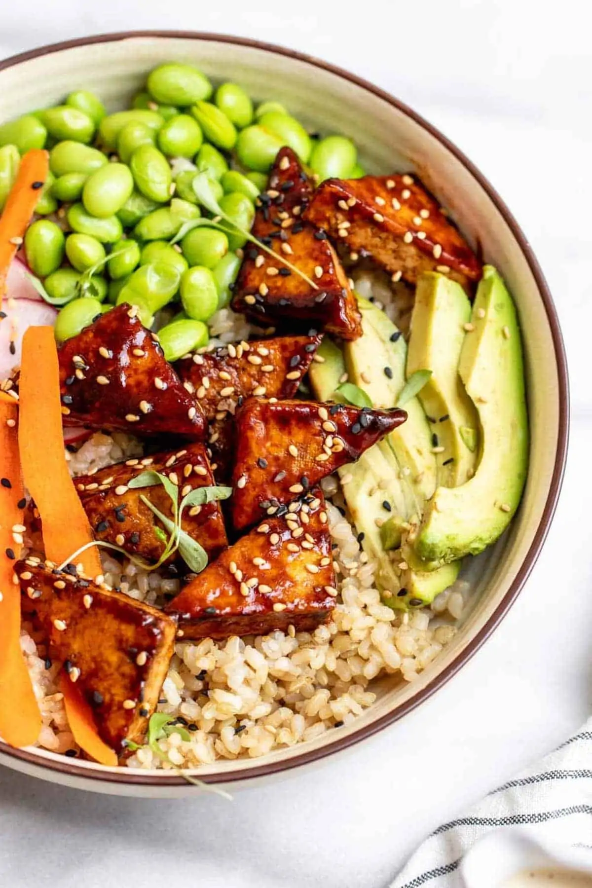 Vegan sushi bowl with tofu, avocado, and rice.