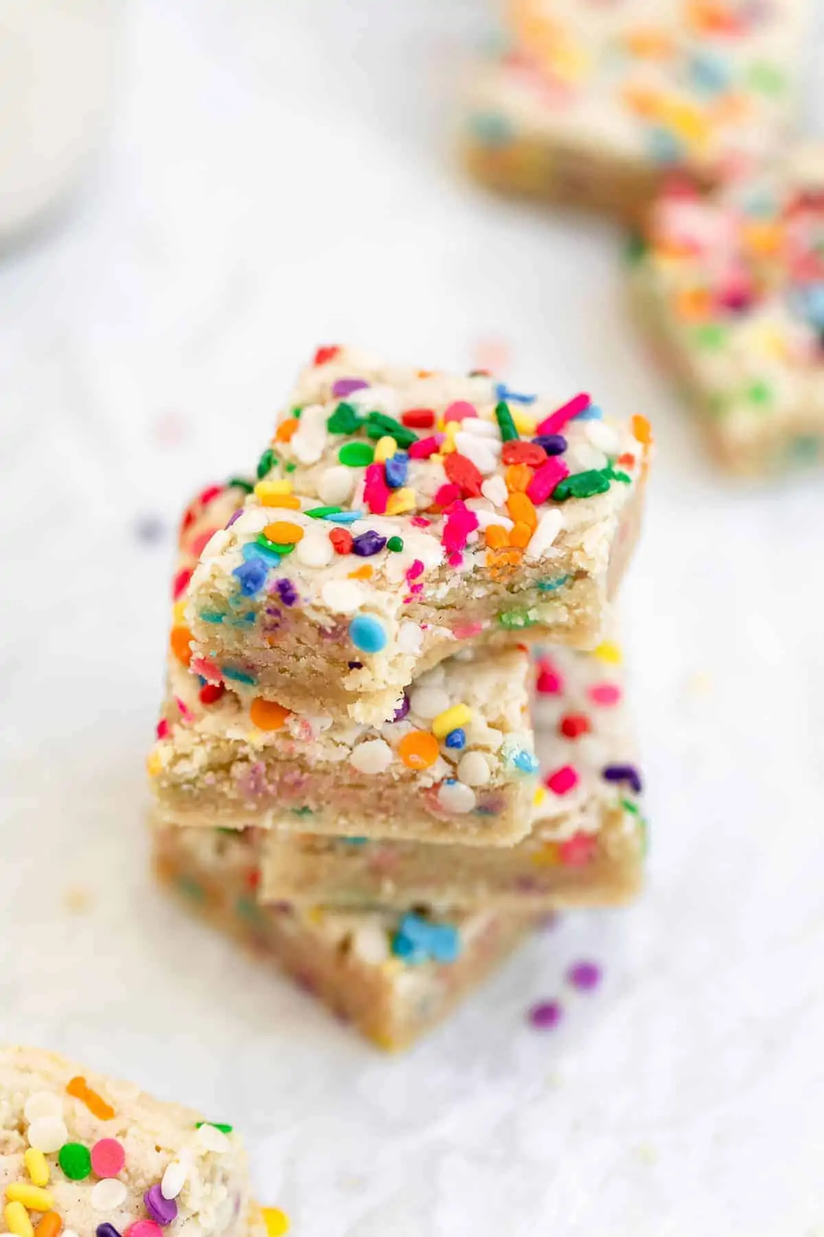 four funfetti blondies stacked on each other with a bite taken out