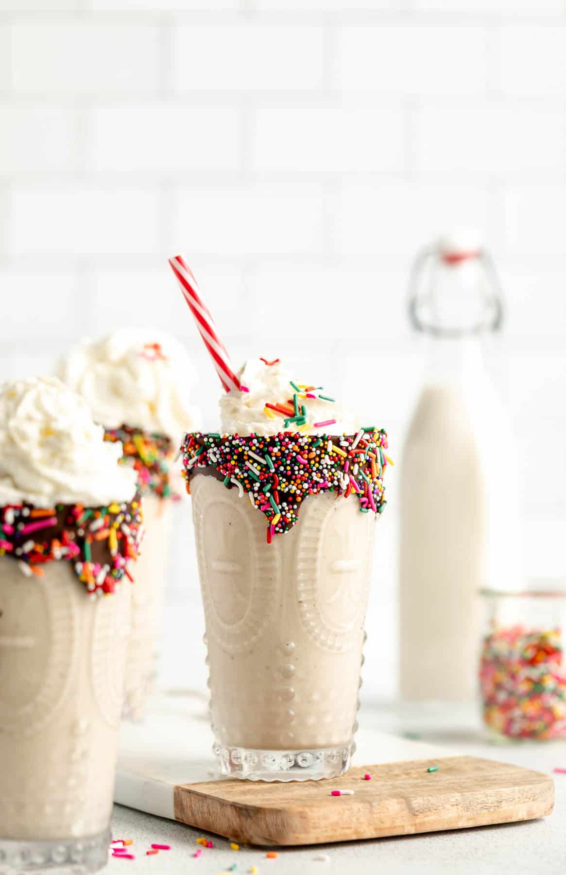 three glasses of the healthy vegan milkshake with chocolate and sprinkles