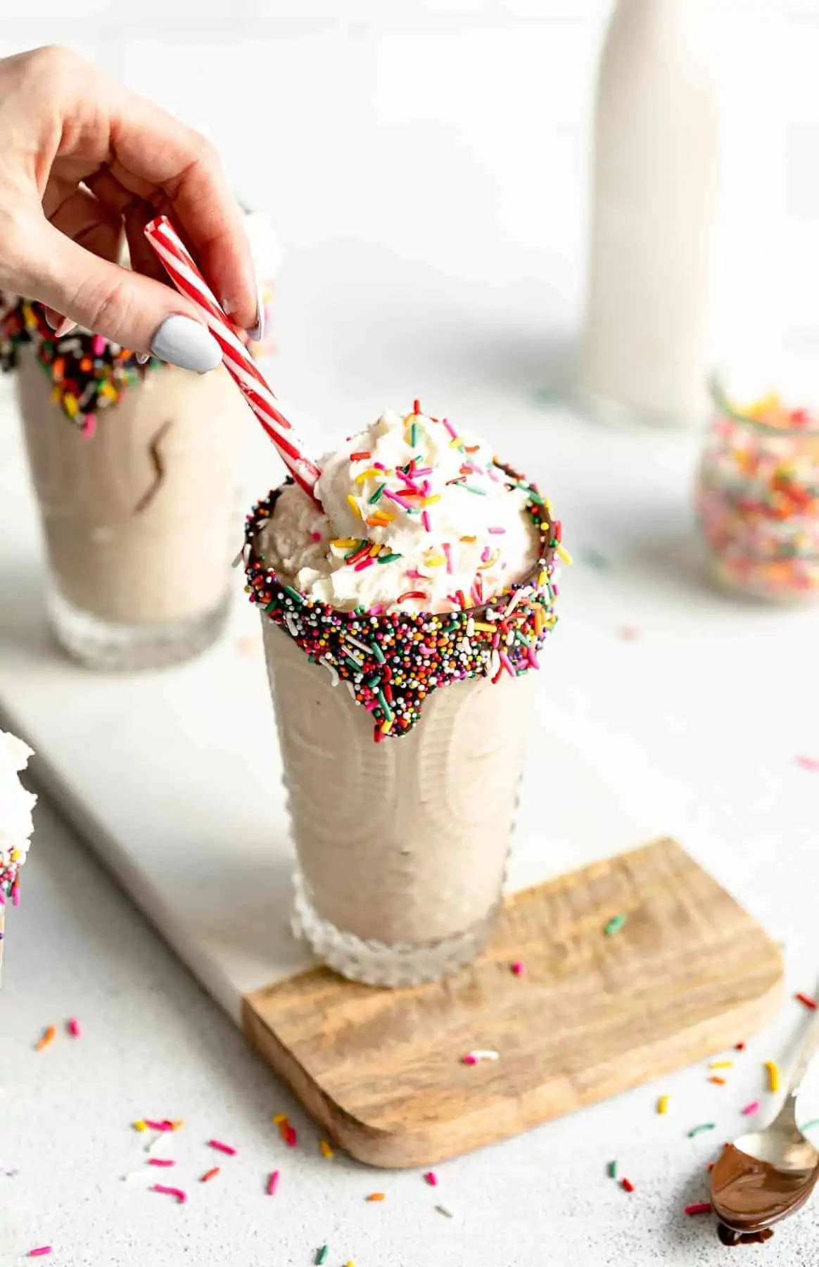 healthy vegan vanilla milkshake in a glass with sprinkles