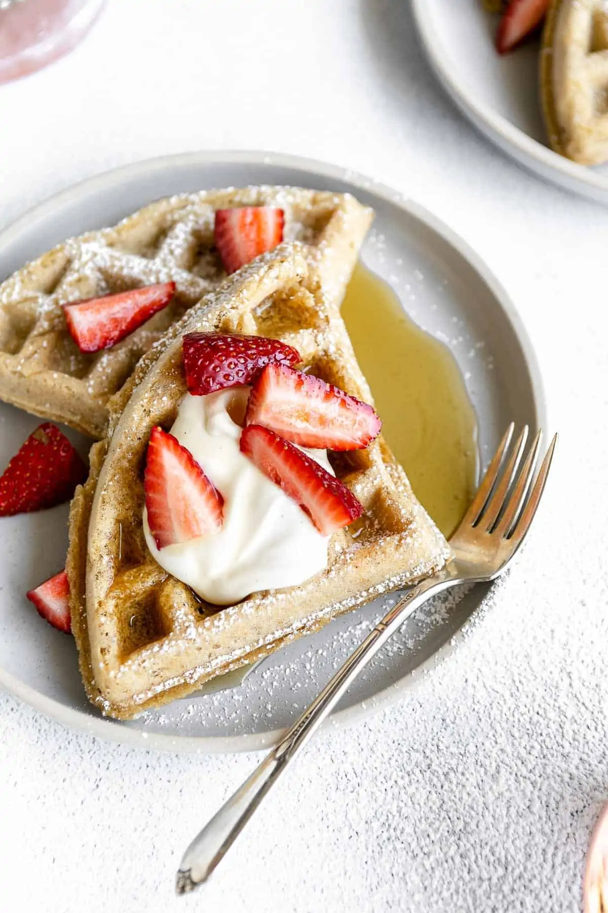 two vegan waffles on a plate with strawberries