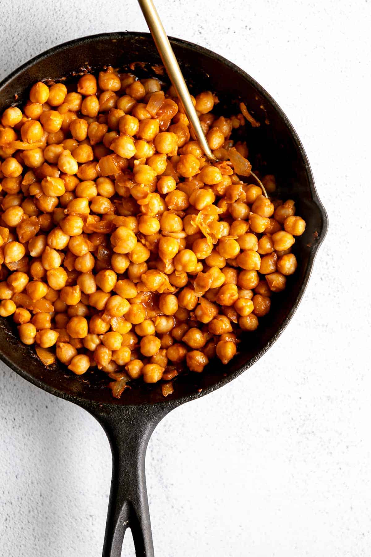 buffalo chickpeas in a skillet with a spoon