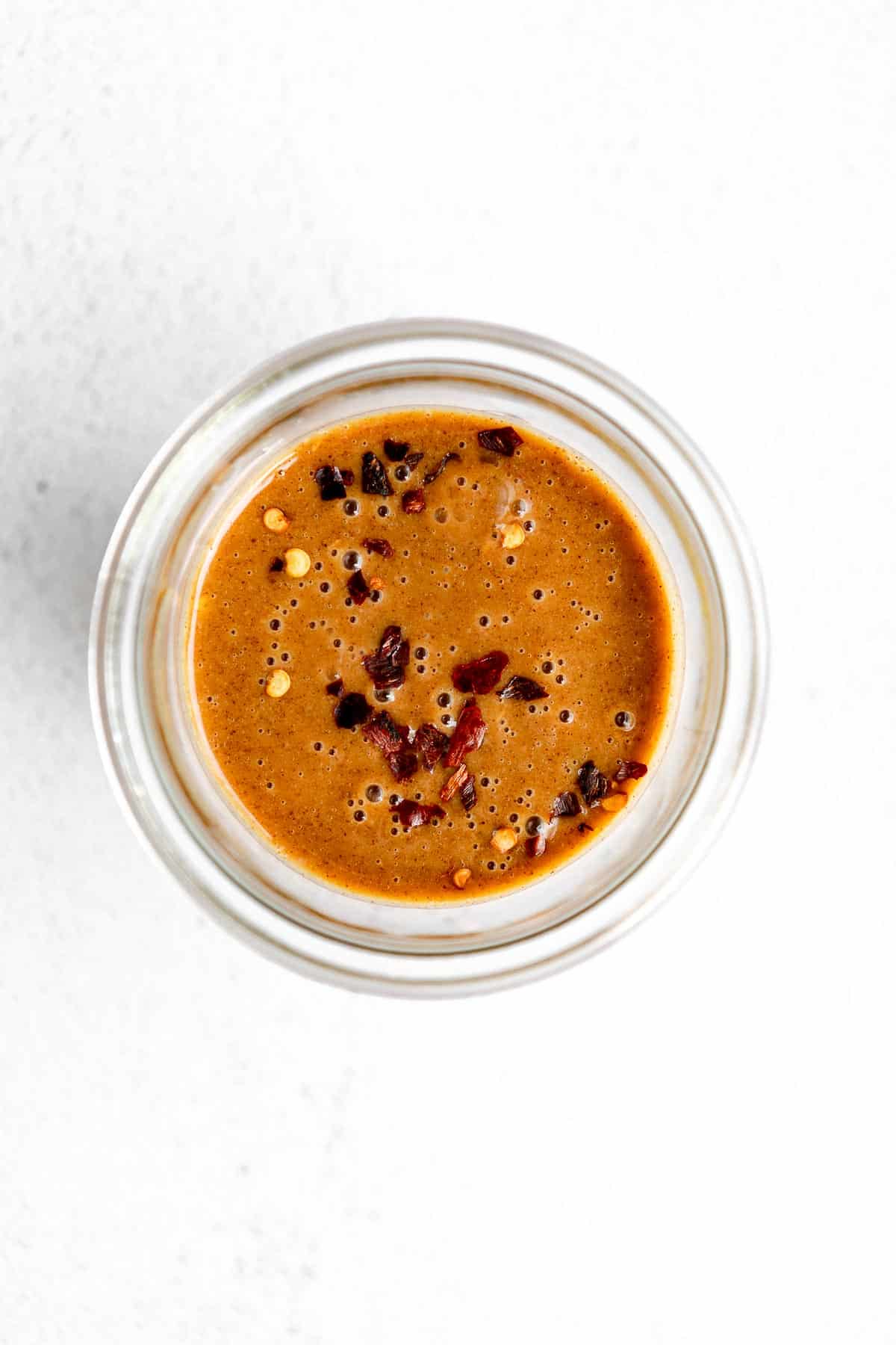 almond butter dressing in a jar with red pepper flakes