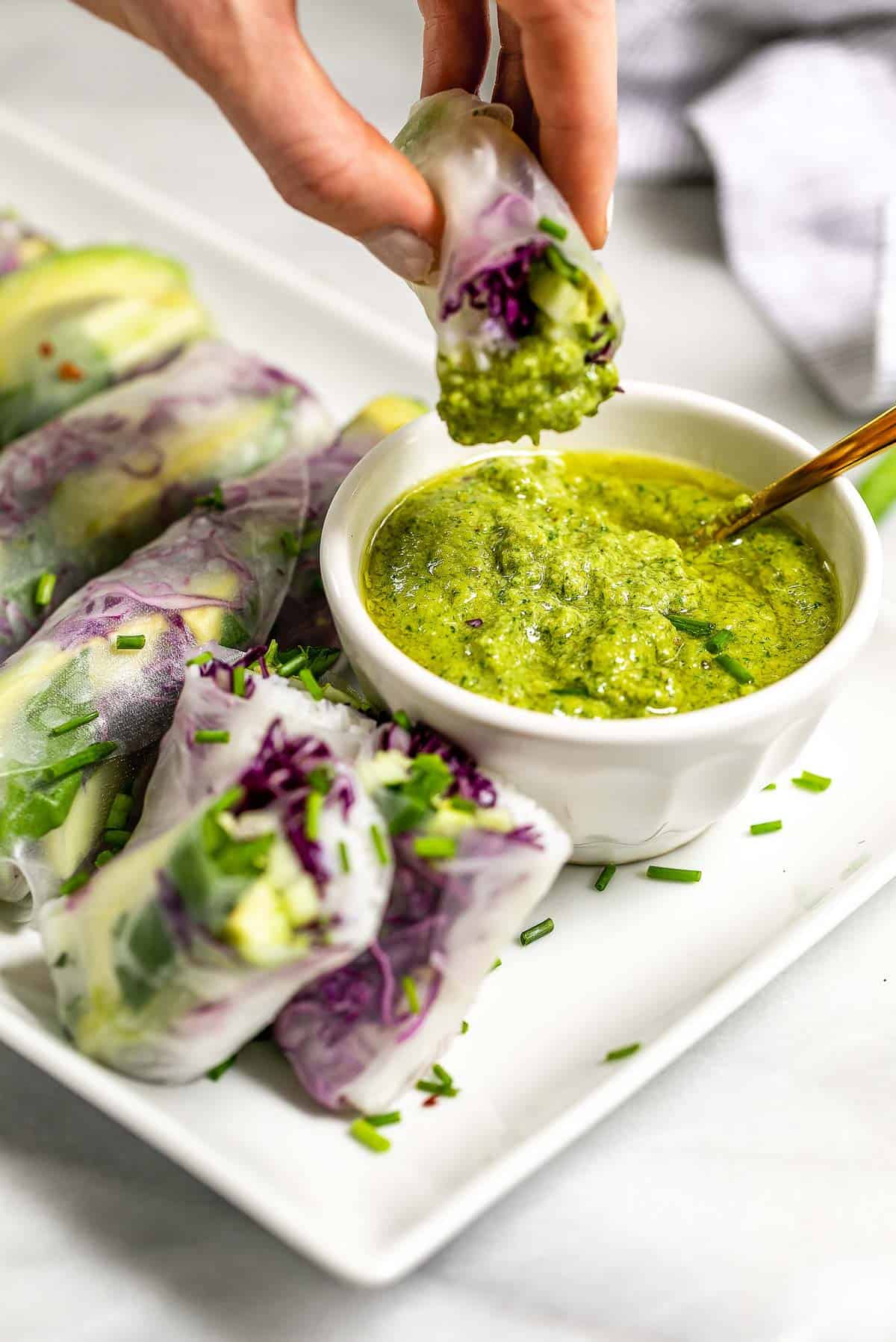 dipping the roll into the pesto sauce