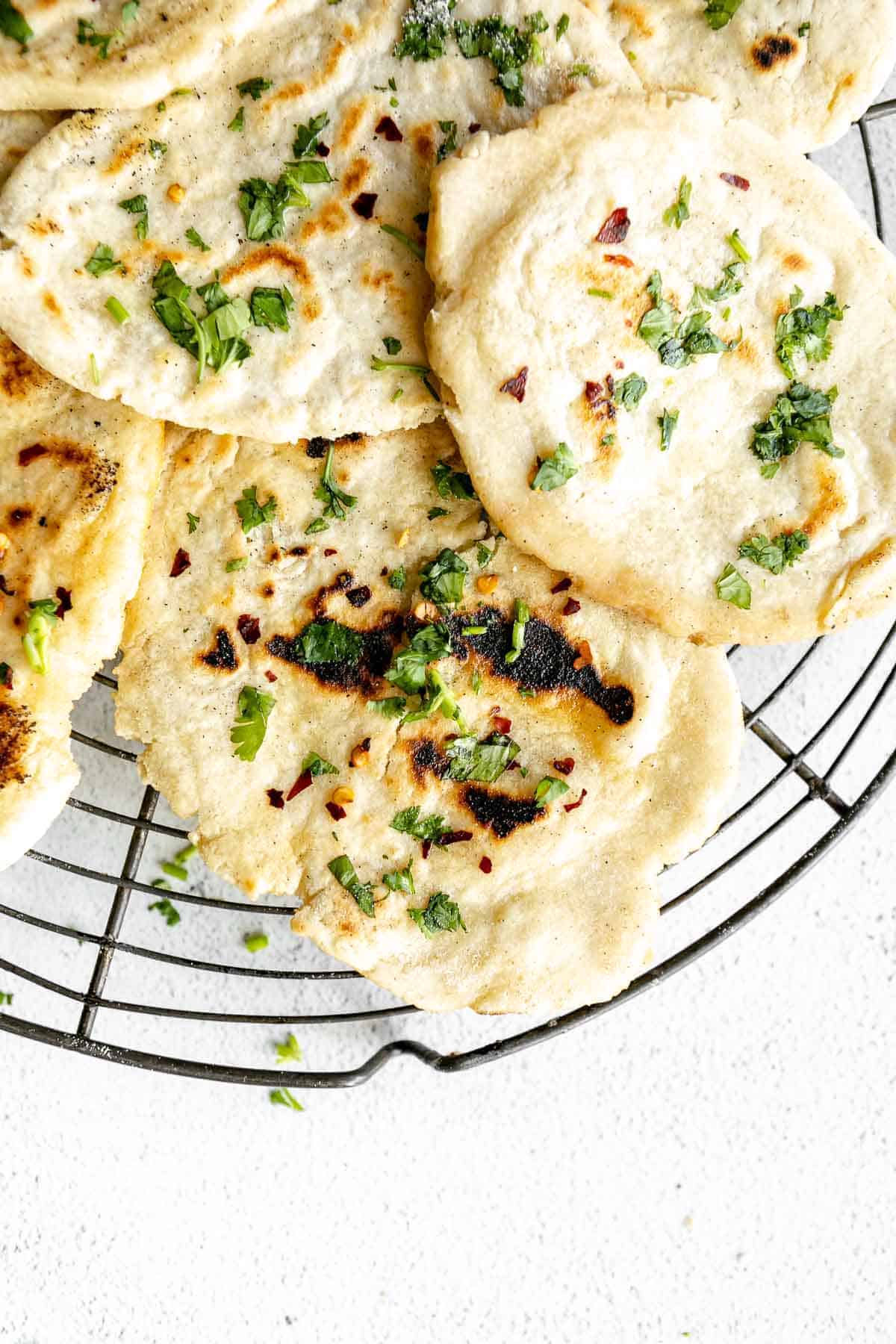 gluten free naan bread on a wire rack with cilantro