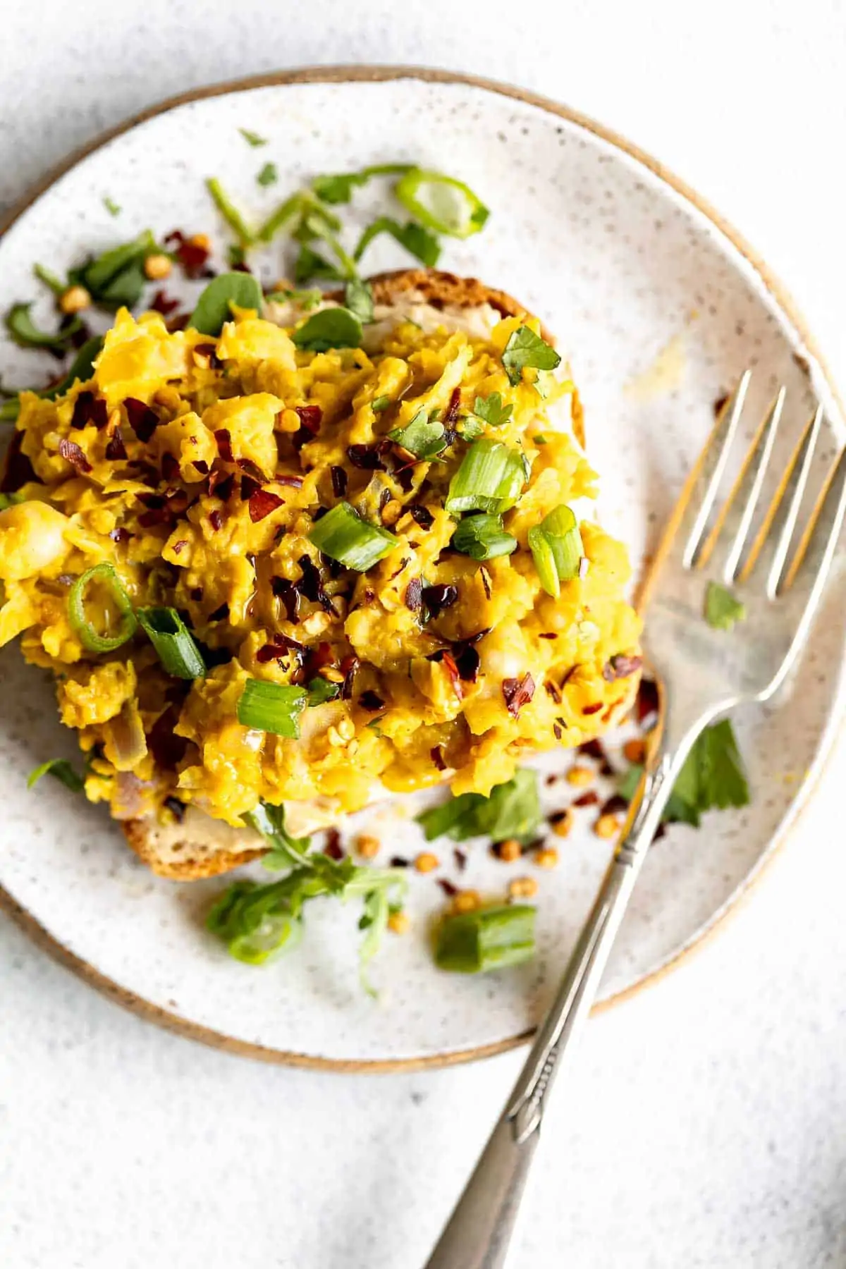 chickpea scramble on toast on a plate with scallions