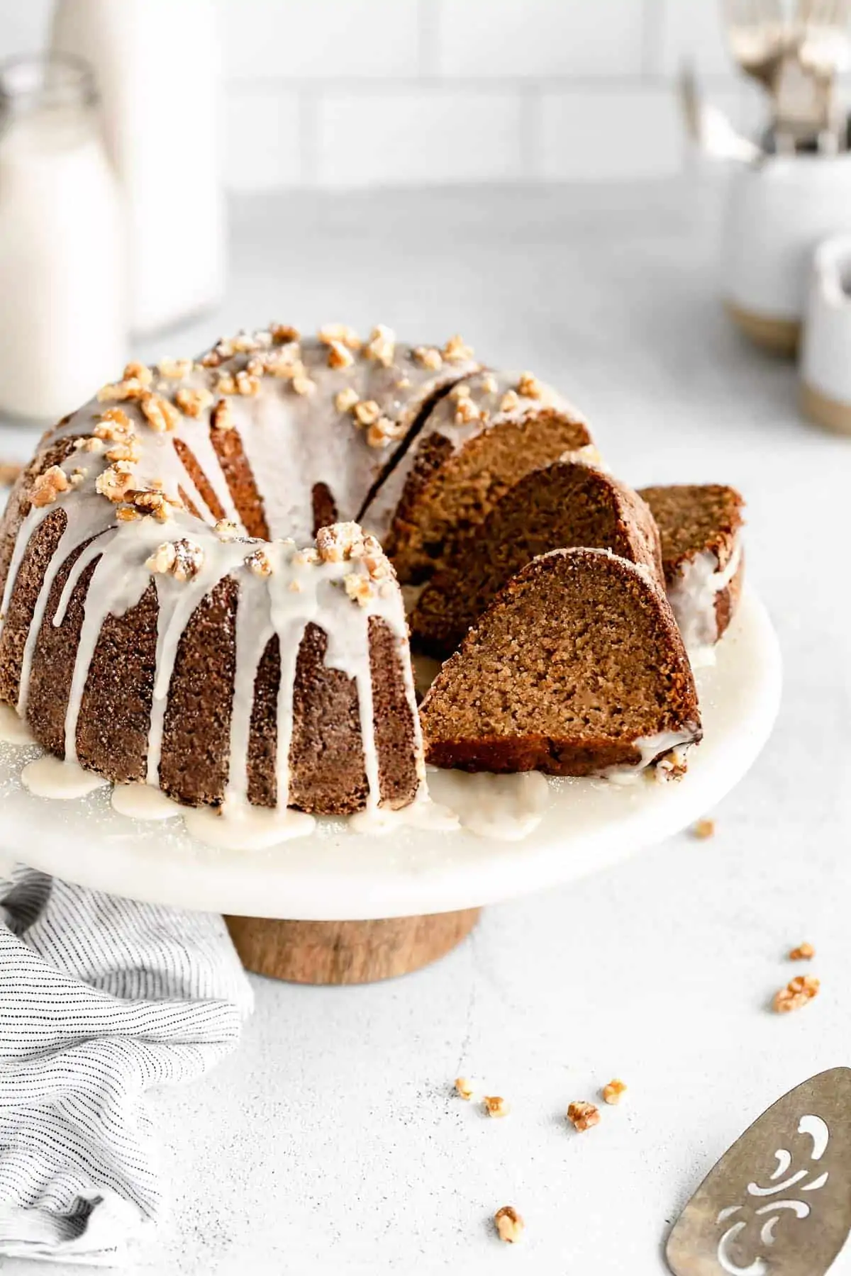 gluten free apple bundt cake on a stand with three slices on the side
