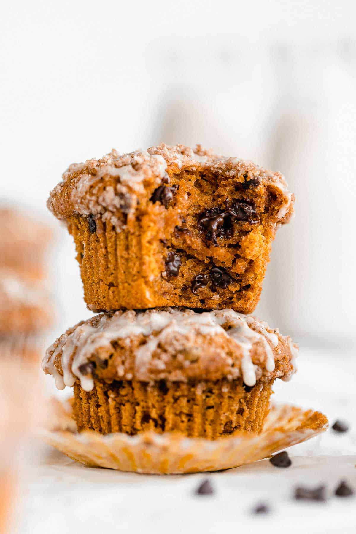 two gluten free pumpkin muffins stacked on each other with chocolate chips