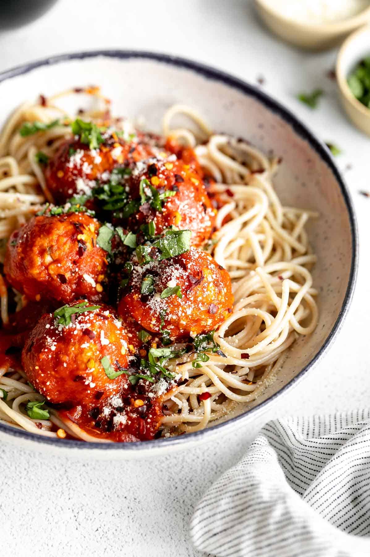 final meatballs in a bowl with spaghetti and parmesan cheese