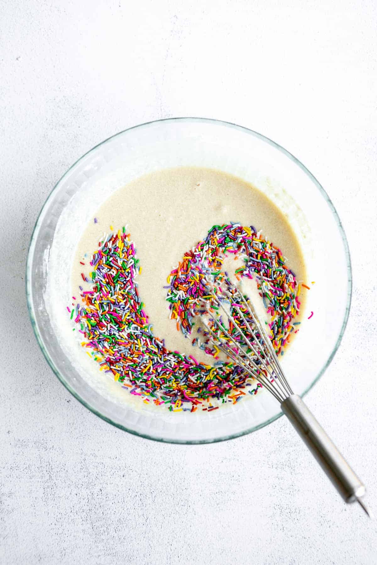 batter in a glass bowl with sprinkles