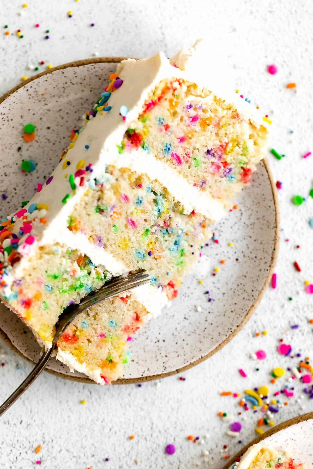gluten free birthday cake slice on a plate with a fork