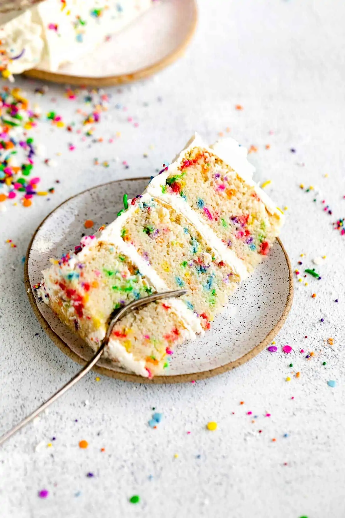 slice of three layer gluten free birthday cake with sprinkles
