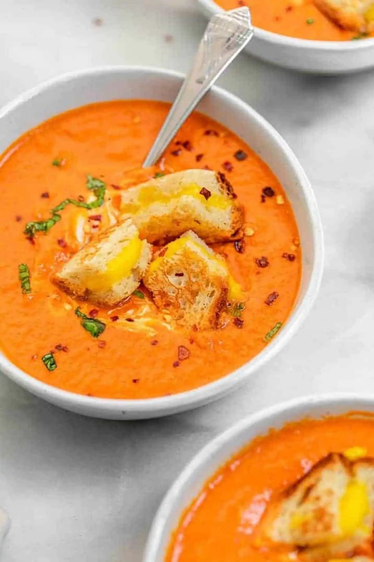 Angled view of vegan tomato soup with grilled cheese in a bowl