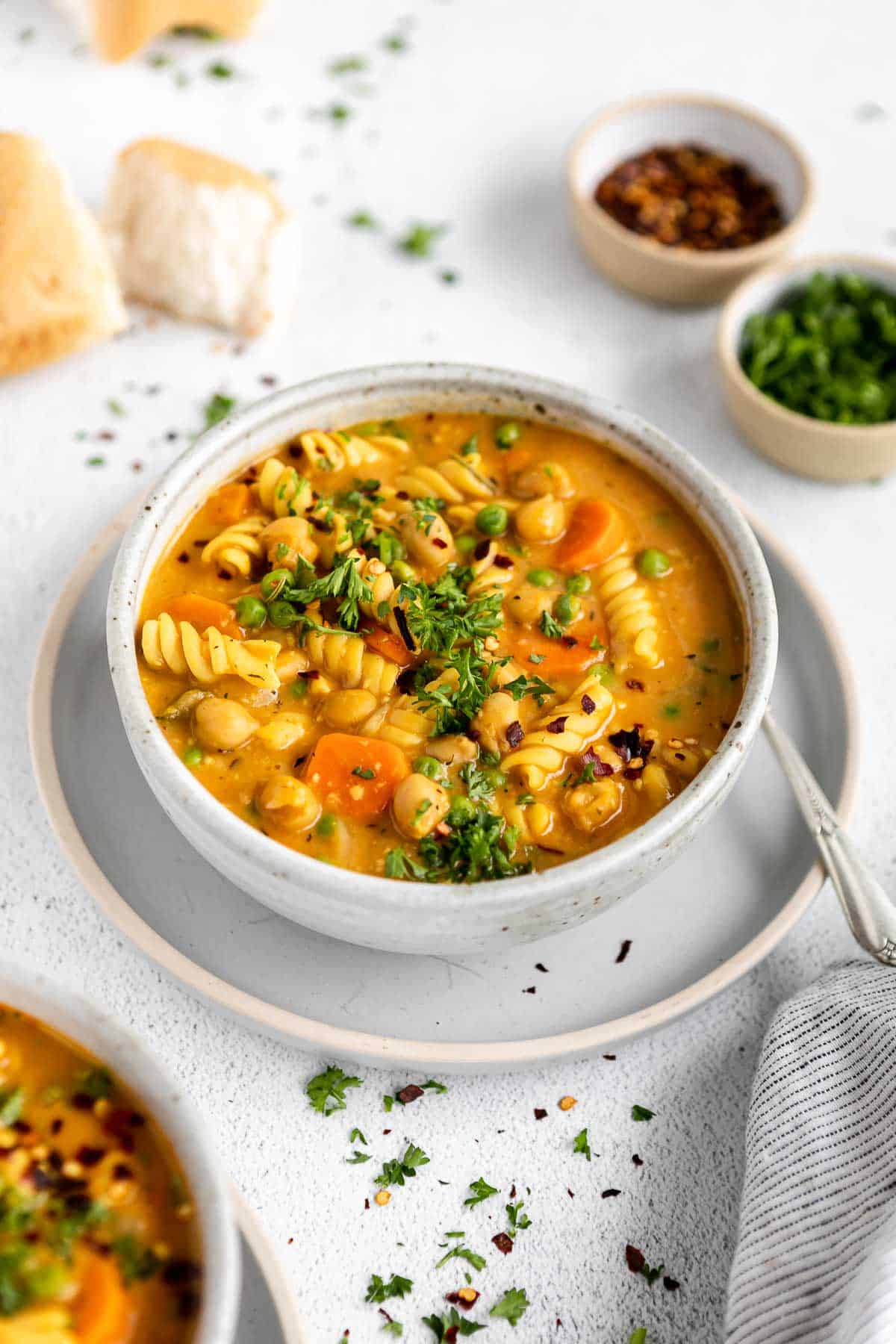 vegan chickpea noodle soup in a bowl with fresh bread