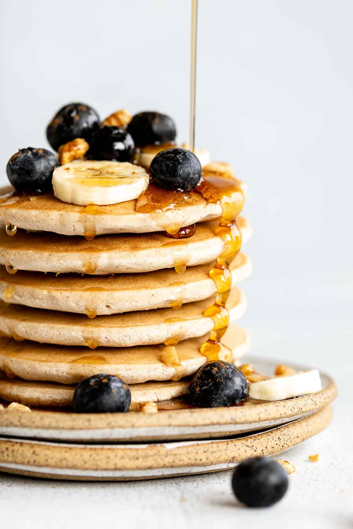up close of the stack of pancakes with maple syrup drips