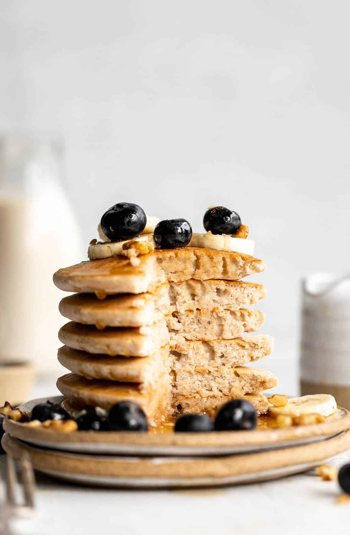 Vegan buckwheat pancakes with slices cut out to show fluffy texture.
