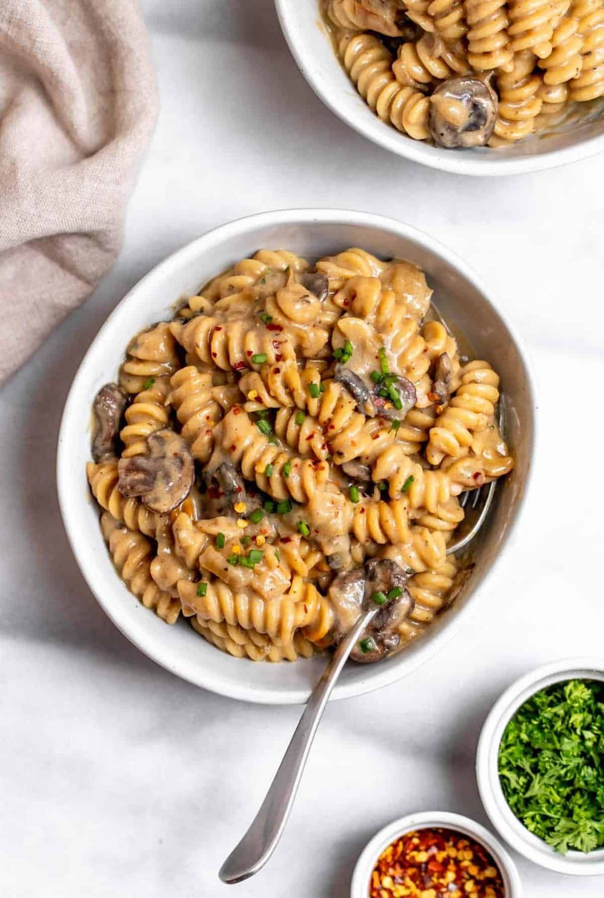 Vegan mushroom stroganoff in a bowl with a fork on the side.