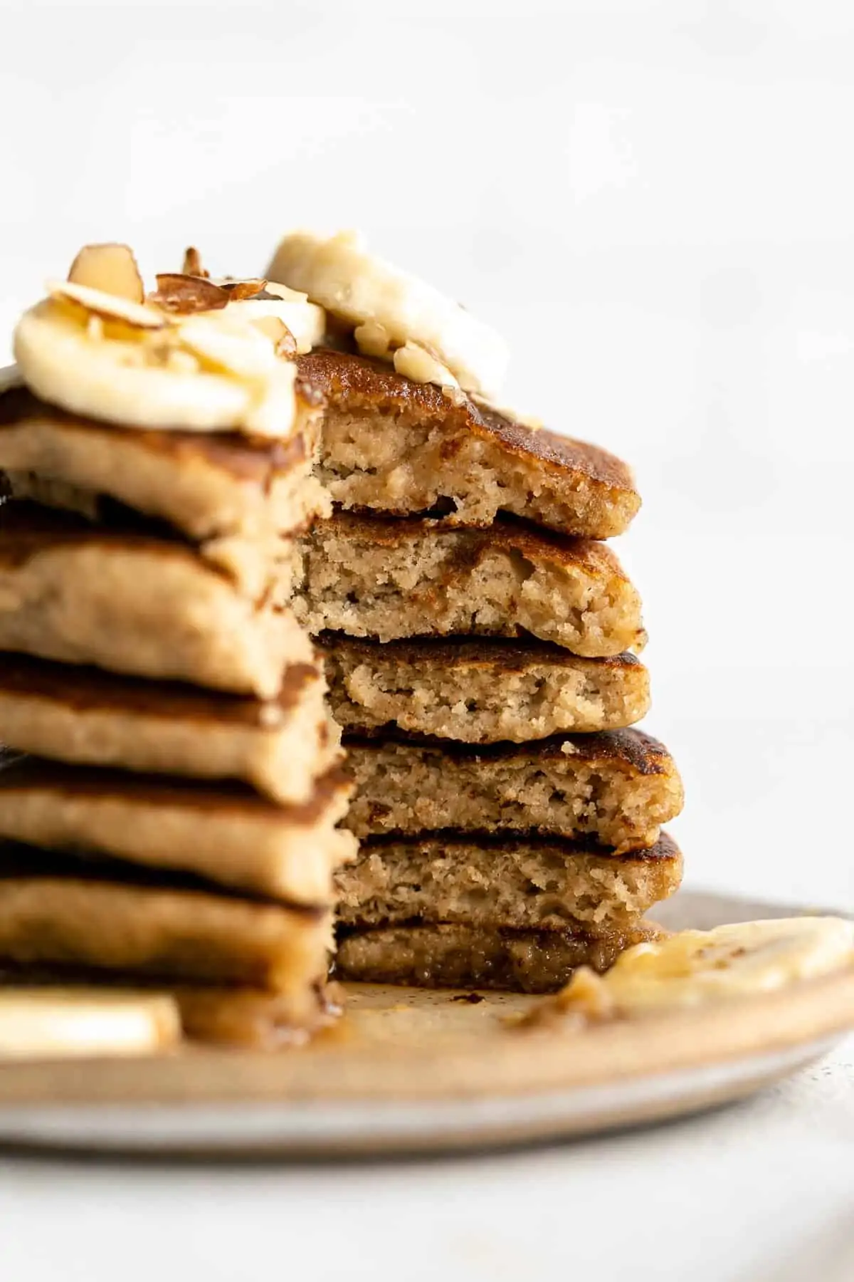 stack of gluten free banana pancakes with a bite taken out to show texture