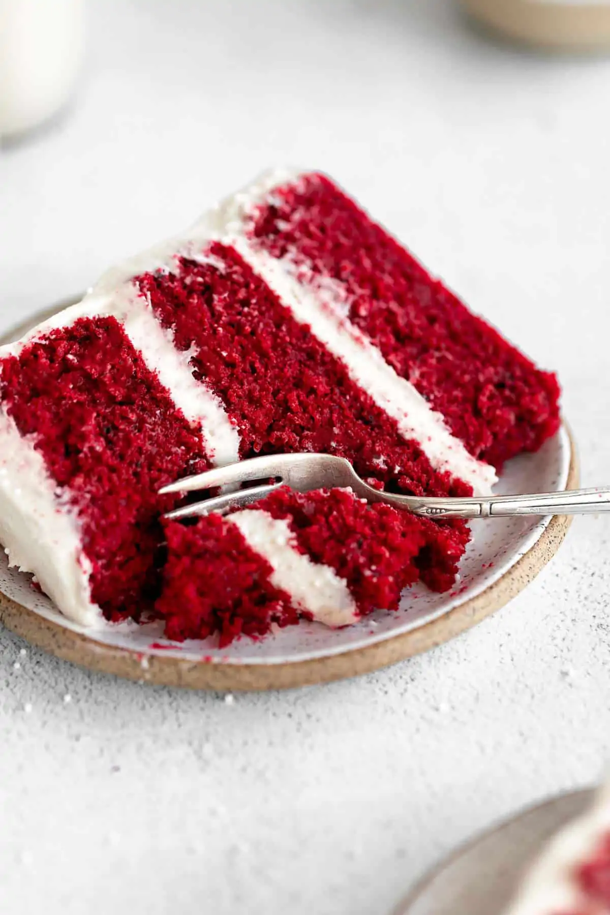 gluten free red velvet cake on a plate with a bite taken out
