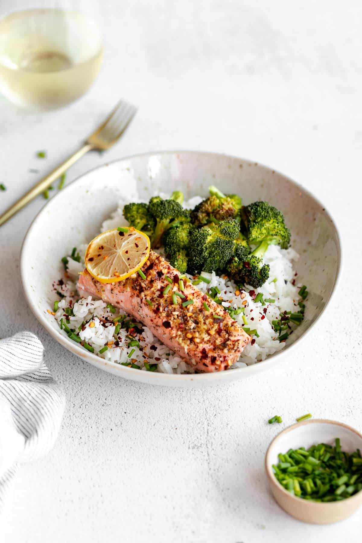 lemon pepper salmon in a bowl with rice and vegeteables