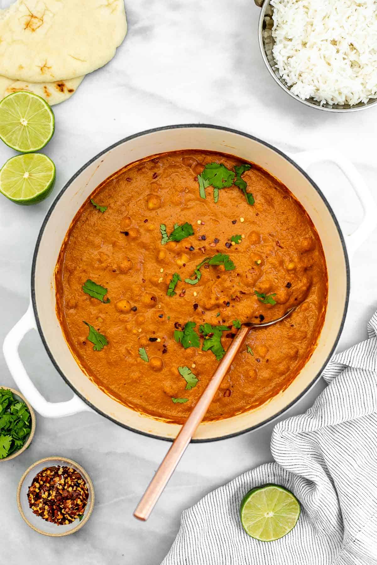 chickpea tikka masala in a pot with a spoon on the side