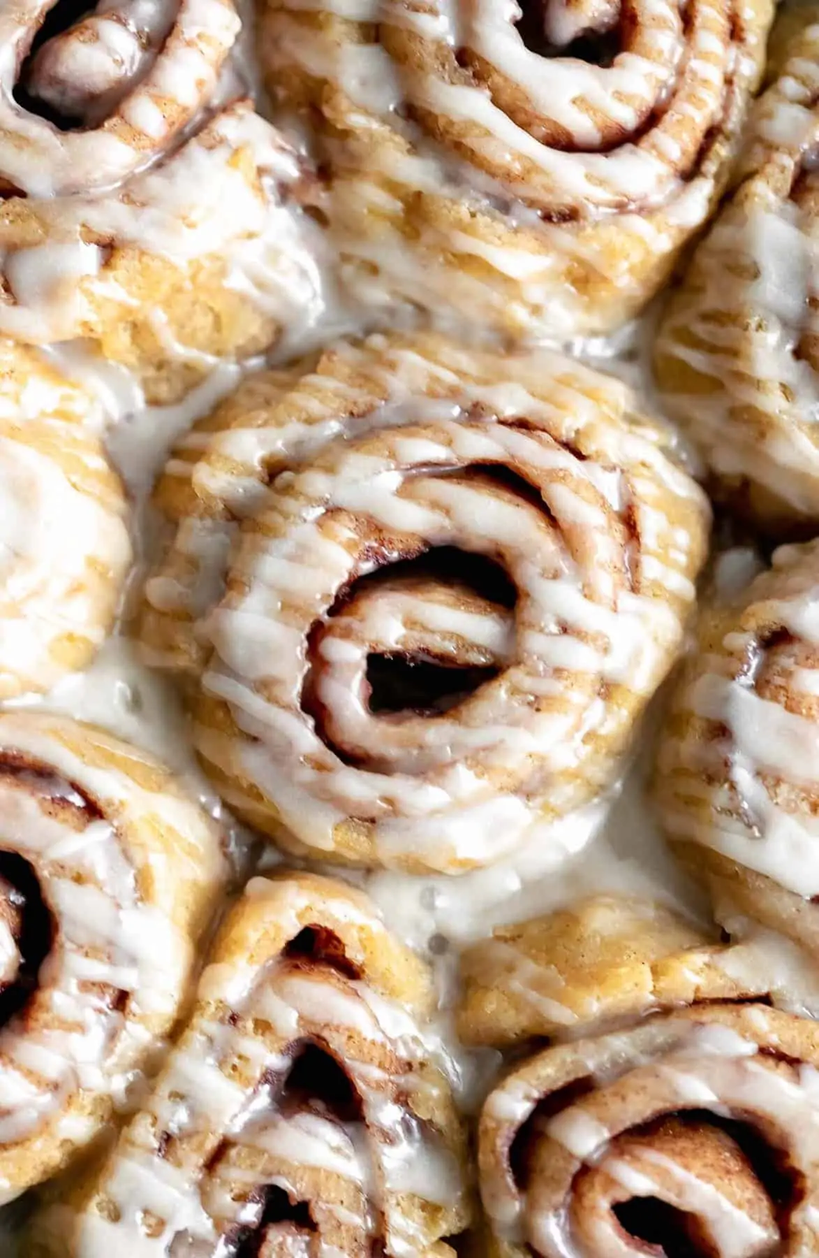 close up of gluten free cinnamon rolls with a drizzle of icing
