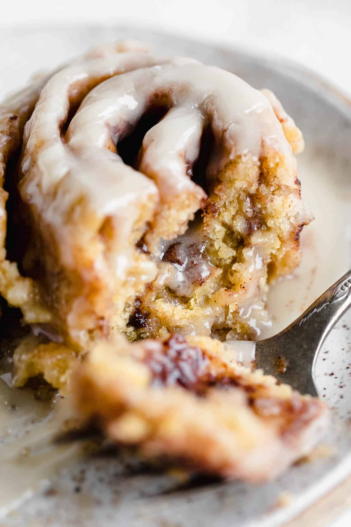 gluten free cinnamon rolls with a bite taken out to show fluffy texture