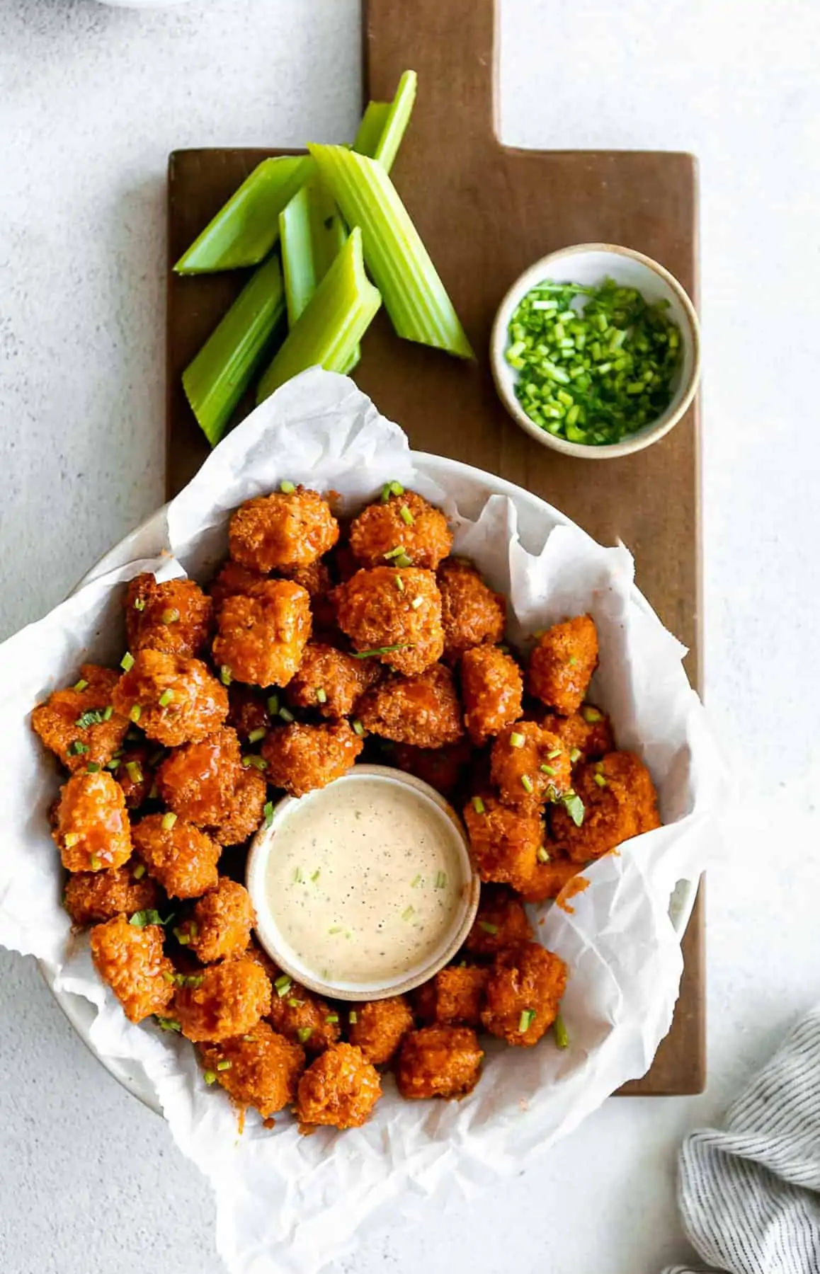 buffalo popcorn chicken in a bowl with celery