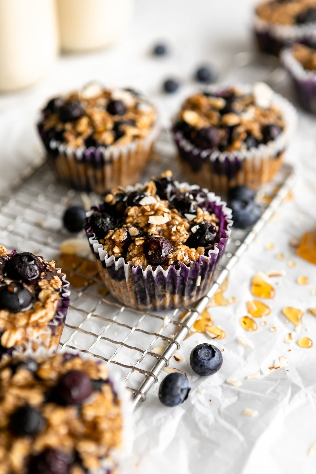 baked oatmeal cups on a wire rack with honey and blueberries