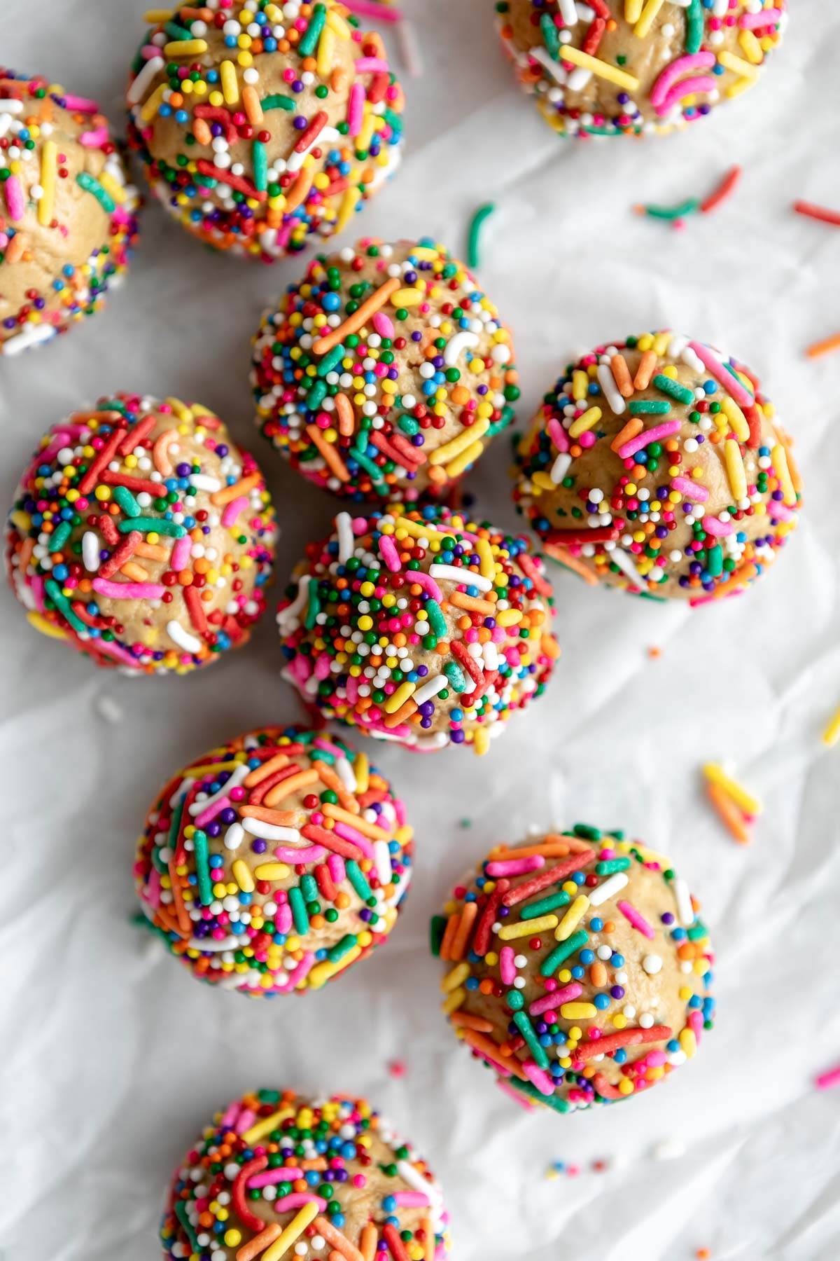 cake batter protein balls with sprinkles on parchment paper