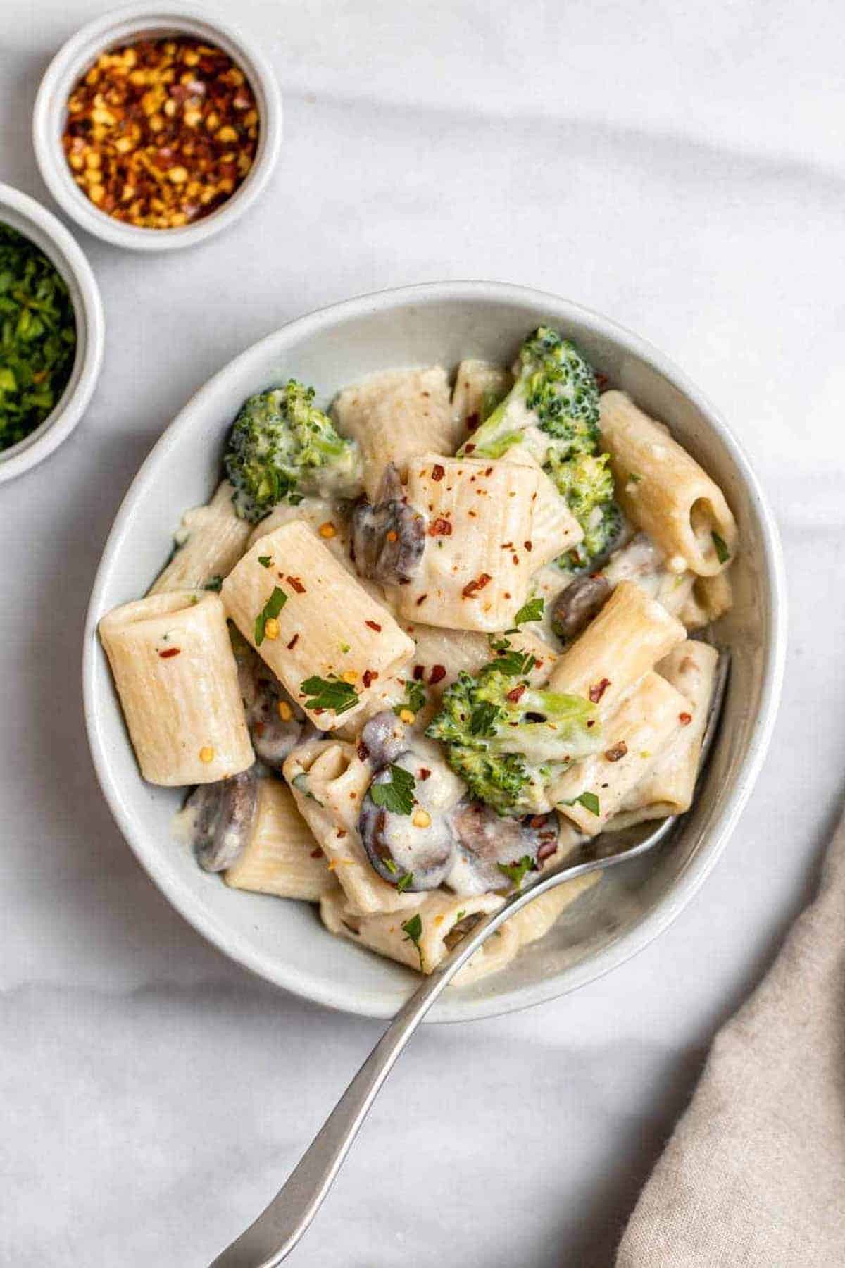 Mushroom broccoli pasta with vegan cream sauce in a small bowl. 