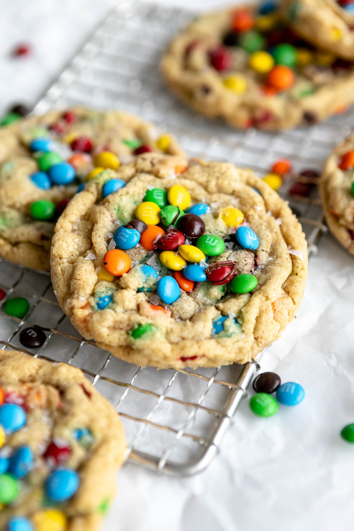 gluten free cookies with m&ms on top on a wire rack