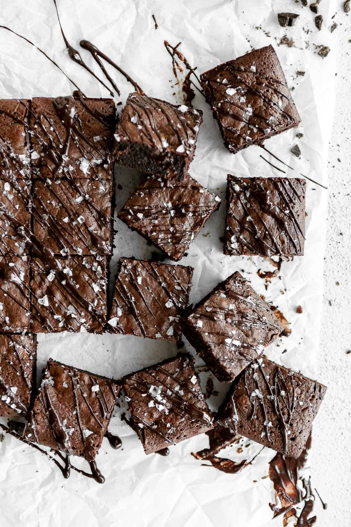 brownies cut into squares on parchment paper with sea salt on top