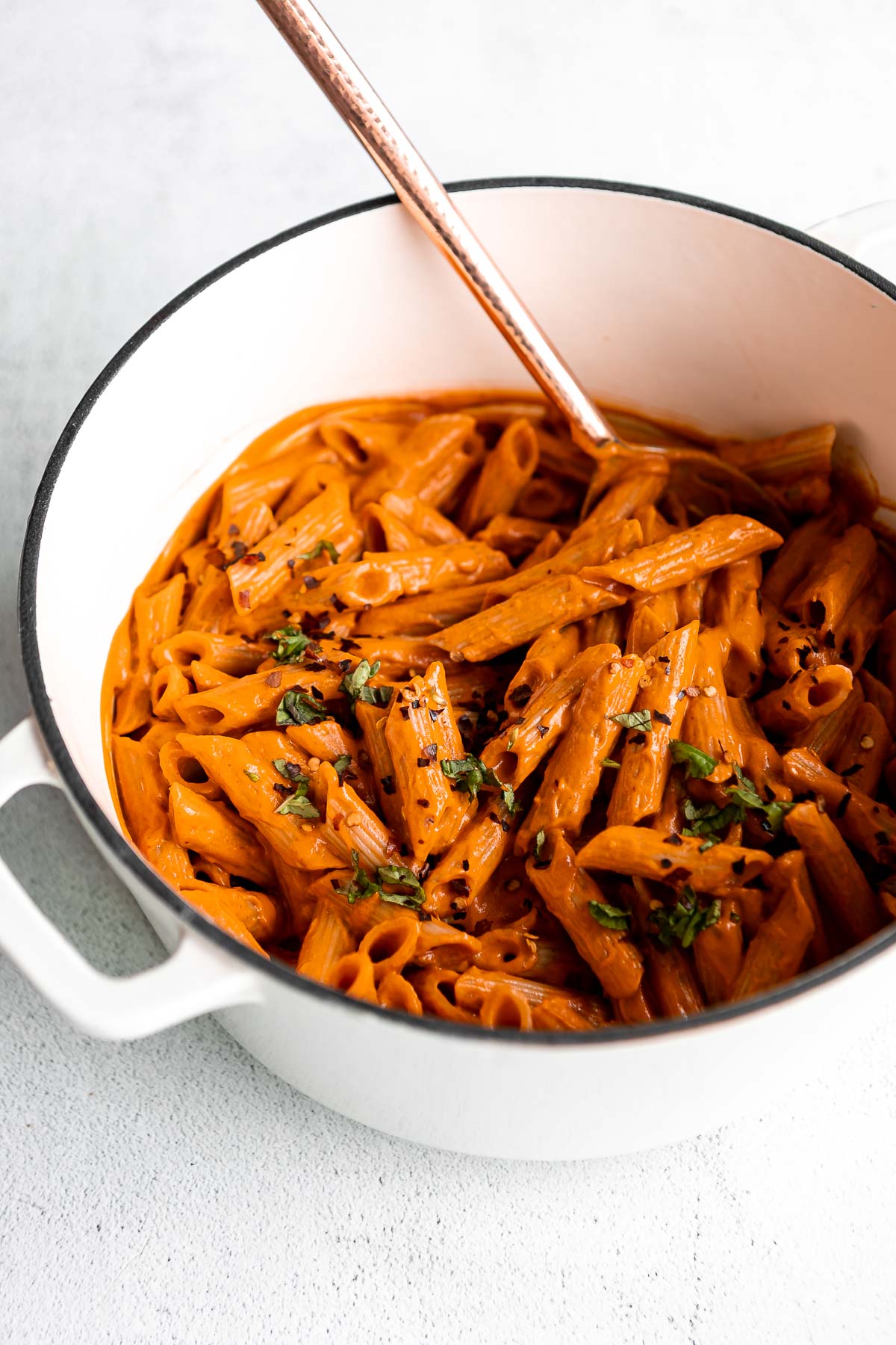 spicy vodka pasta in a white pot with red pepper flakes